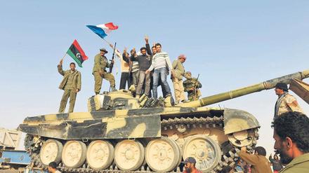 Farben der Rebellen. Aufständische schwenken auf einem von den Gaddafi-Truppen erbeuteten Panzer die französische Flagge und ihre Revolutionsfahne. 