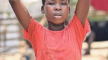 Opfer des Krieges. Ein zwölfjähriges Flüchtlingskind trägt in einem Lager an der Grenze zwischen der Elfenbeinküste und Liberia einen Eimer mit Wasser.