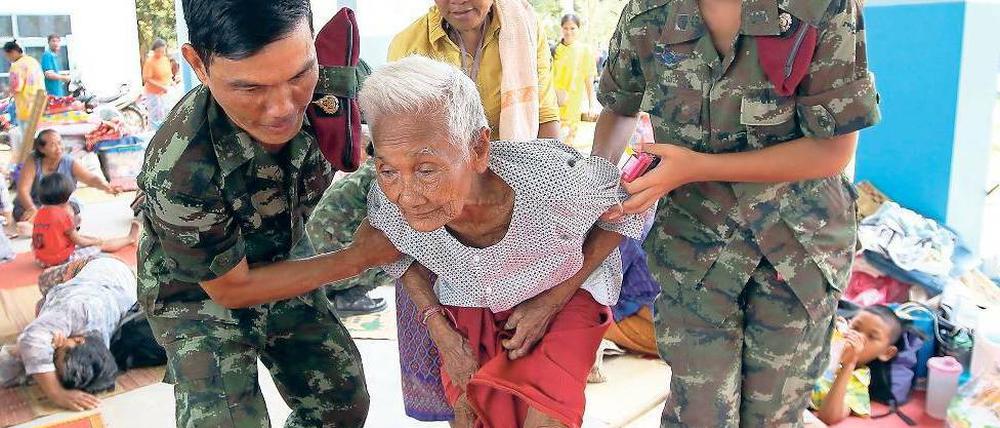 Zivilisten in Not. Thailändische Soldaten helfen einem Dorfbewohner. Foto: dpa