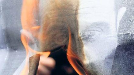 Protest. Demonstranten verbrennen ein Bild von Syriens Staatschef Assad.