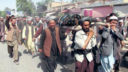 Volkszorn. Wütende Afghanen tragen die Leichen von Männern und Frauen durch die Straßen von Talokan, die zuvor bei einem Nato-Angriff getötet worden waren. Die Demonstranten skandierten Parolen wie „Tod den USA“ und „Tod Karsai“. Foto: Reuters