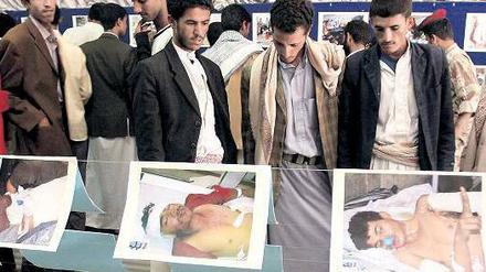 Schaurige Ausstellung. Besucher in der jemenitischen Hauptstadt Sanaa betrachten Fotos von Regierungsgegnern, die bei Demonstrationen und Kämpfen verletzt oder getötet wurden. 