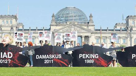 Nicht von Pappe. Aktivisten des Kampagnennetzwerks „Campact“ demonstrieren vor dem Reichstag mit Nachbildungen von Panzern gegen Waffenexporte. Foto: Michael Gottschalk/dadp