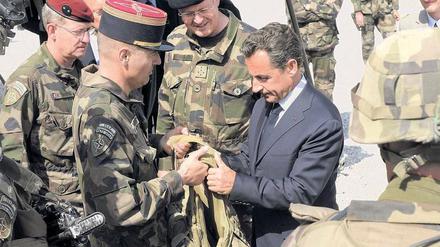 Anschauungsunterricht. Frankreichs Präsident Nicolas Sarkozy lässt sich bei seinem Kurzbesuch auf einem Stützpunkt in der Nähe der afghanischen Hauptstadt Kabul eine kugelsichere Weste zeigen. Foto: Philippe Wojazer/AFP