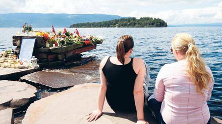 Utöya. Zwei Frauen sitzen beim temporären Mahnmal vis-a-vis der Insel nahe der norwegischen Hauptstadt Oslo, wo der Attentäter am vergangenen Freitag in einem Feriencamp unter zahlreichen Jugendlichen ein Massaker anrichtete. 