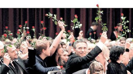 Den Ofern zu Ehren. Norwegische Sozialdemokraten mit Premier Jens Stoltenberg in der Mitte halten bei einer Gedenkveranstaltung für die von Anders Behring Breivig Ermordeten Rosen in den Händen. Foto: Berit Roald/dpa