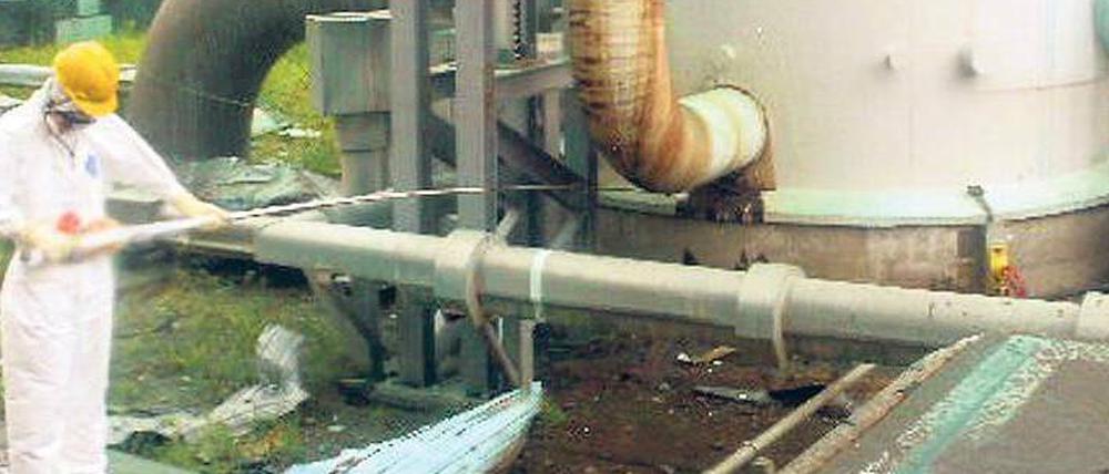Ein Tepco-Arbeiter misst an einem Rohr in Fukushima die Ortsdosisleistung. Das Foto hat die Firma einen Tag nach der Messung veröffentlicht. Nun soll geklärt werden, ob es weitere stark strahlende Stellen gibt. 