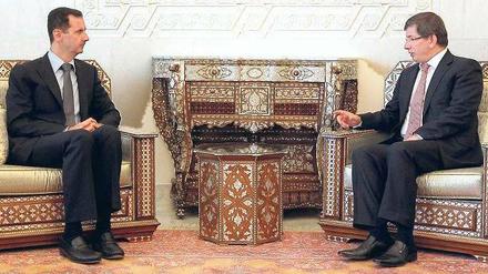 Angespannt ist inzwischen das Verhältnis der einstigen Freunde Syrien und Türkei. Auch das Treffen zwischen Präsident Baschar al Assad (links) und Ankaras Außenminister Ahmet Davutoglu in Damaskus verlief am Dienstag augenscheinlich nicht in lockerer Atmosphäre. 