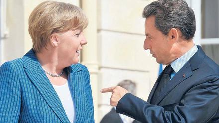 Entspanntes Gespräch. Bevor es ans Eingemachte ging, zeigten sich Merkel und Sarkozy am Dienstag auf den Stufen des Elysée-Palastes den Fotografen. Foto: Horacio Villalobos/dpa