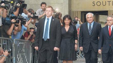 Eine lange Gefängnisstrafe drohte dem ehemaligen IWF-Chef Dominique Strauss-Kahn (3.v.l.). Am Dienstag jedoch wurde das Verfahren eingestellt, und er verließ das Gericht in Begleitung seiner Frau sichtlich erleichtert. Foto: AFP