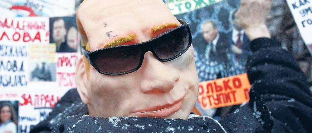 Allgegenwärtig. Bei der Großkundgebung in Moskau am Samstag trug ein Demonstrant eine Putin-Maske. Der russische Premier lässt Kritik am Ablauf der Duma-Wahl zurückweisen. Foto: Reuters