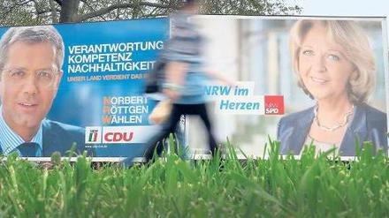 Auf den Plakaten sind sie nett. Aber der bislang eher langweilige Wahlkampf in NRW ist gut eine Woche vor dem Urnengang doch etwas schärfer geworden. Denn Rot-Grün muss um die sicher geglaubte Mehrheit bangen. Foto: Martin Gerten/dpa