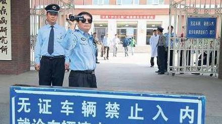 Im Visier der Polizei. Vor dem Pekinger Chaoyang-Krankenhaus, in dem sich der Menschenrechtsaktivist Chen und seine Familie befinden, filmt ein Polizeibeamter ausländische Journalisten. Foto: Mark Ralston/AFP