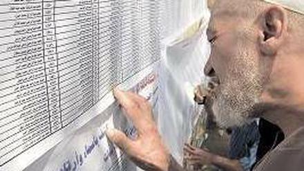 Ein Wähler sucht auf einer Liste vor einem Wahllokal nach seinem Namen. Foto: AFP