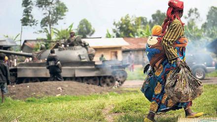 Unschuldige Opfer. Eine Frau flieht mit ihrem Kind vor den Auseinandersetzungen von Regierungstruppen und Rebellen in der Demokratischen Republik Kongo.
