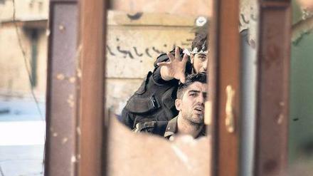 Kämpfer in Aleppo beobachten mithilfe eines Spiegels einen Posten der regulären Armee. Auf eine internationale Militärintervention setzen sie nicht mehr. Foto: Marco Longari/AFP