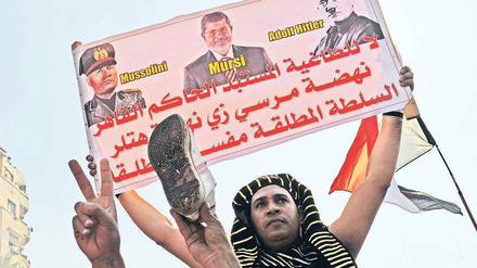 Die Volksseele kocht. Ein Demonstrant hält in Kairo ein Protestplakat gegen Mohammed Mursi hoch, das Ägyptens Staatschef mit Hitler und Mussolini vergleicht.Foto: Katharina Eglau