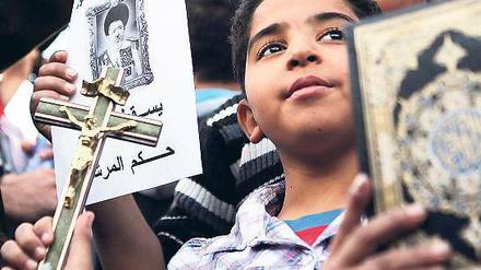 Friedlicher Widerstand. Zwei Jungen halten bei einem Protestmarsch zum Präsidentenpalast von Mohammed Mursi in Kairo ein Kruzifix und eine Kopie des Koran in der Hand.Foto: dpa