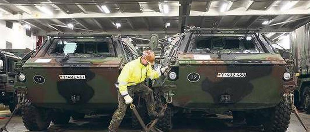 Ein Soldat kontrolliert die Sicherung eines ABC-Spürpanzers während der Verladung einer Patriot-Einheit der Bundeswehr im Hafen von Lübeck-Travemünde. Foto: dpa