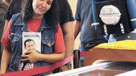 Am halb offenen Sarg. Eine Frau trauert in der Militärakademie der Hauptstadt Caracas um Venezuelas verstorbenen Staatschef Chávez. Am Sarg hielt eine vierköpfige Ehrengarde Wache. Foto: AFP