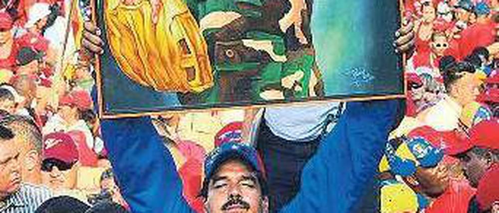 Nicolás Maduro will Präsident werden. Dafür hält er ein Plakat des verstorbenen Präsidenten Hugo Chávez hoch. In den Umfragen liegt der ehemalige Busfahrer vorn. Foto: AFP