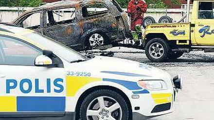 Spuren der Ausschreitungen: Ein ausgebranntes Auto im Vorort Husby. Foto: AFP