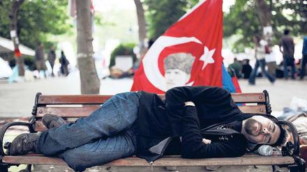 Parkschützer auf türkisch. Der junge Mann auf der Parkbank des Taksim-Platzes hat auch seine Erholungspause in die seit einer Woche umkämpfte Zone verlegt.