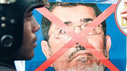 Ein Plakat, auf dem das Bild von Ägyptens Präsident Mursi durchgestrichen ist. 