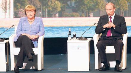 Gute Laune sieht anders aus. Angela Merkel und Wladimir Putin saßen am Freitag beim Petersburger Wirtschaftsforum gemeinsam auf dem Podium. Anschließend bemühten sie sich um eine Schlichtung des Streits um die Beutekunst. Foto: Anatoly Maltsev/dpa