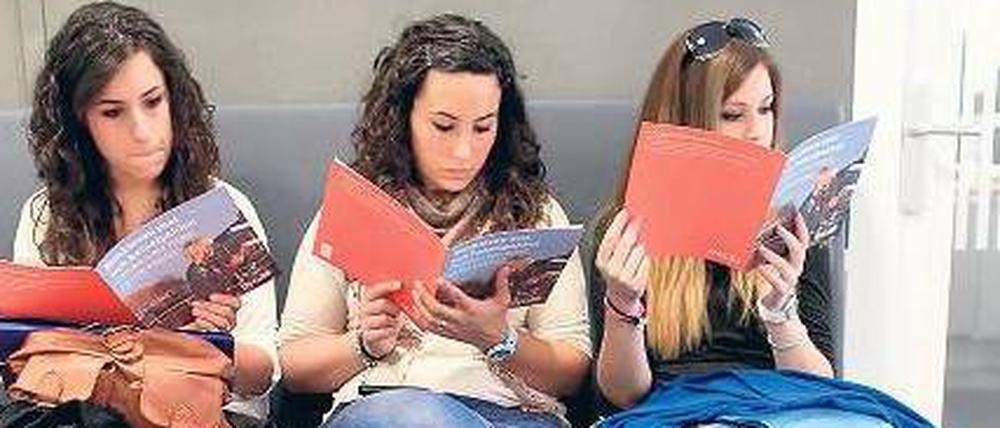 Bereit zur Auswanderung. Drei junge spanische Krankenschwestern lesen Broschüren mit Informationen über einen Neustart in einem anderen europäischen Land. Denn die Krise in Spanien dürfte noch länger anhalten.