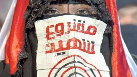 Eine Anhängerin des abgesetzten Präsidenten Mohammed Mursi trägt ein Schild mit der Aufschrift „Märtyrerprojekt“.