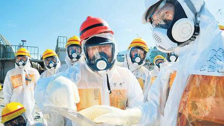 Kontrollgang. Japans Wirtschaftsminister Toshimitsu Motegi (Mitte) besucht das Atomkraftwerk in Fukushima. Die Regierung ist mit dem Krisenmanagement der Betreiberfirma Tepco unzufrieden und will nun selbst eingreifen. Foto: Reuters