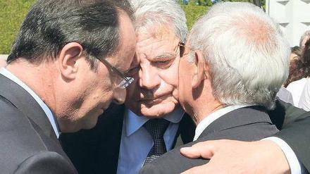 Eine Geste sagt mehr als staatsmännische Worte: Der Bundespräsident (Mitte) und Frankreichs Staatschef François Hollande (links) umarmen den 87-jährigen Robert Hébras, einen Überlebenden des SS-Massakers in Oradour. 