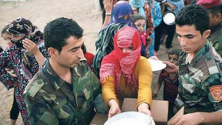 Erste Hilfe. In einem Flüchtlingscamp an der irakischen Grenze werden Syrer mit Lebensmitteln versorgt.