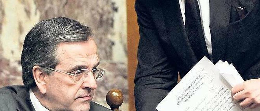 Etappensieg. Finanzminister Yiannis Stournaras (r.) und Premierminister Antonis Samaras Samstagnacht bei der Haushaltsdebatte im Parlament. Foto: Louisa Gouliamaki