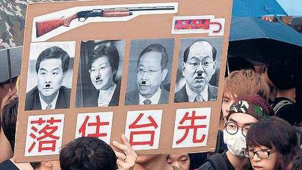 Verunglimpft. Demonstranten zeigen Männer mit Schnurrbärten, die an Adolf Hitler erinnern sollen. Unter ihnen ist Hongkongs Regierungschef Leung Chun Ying.