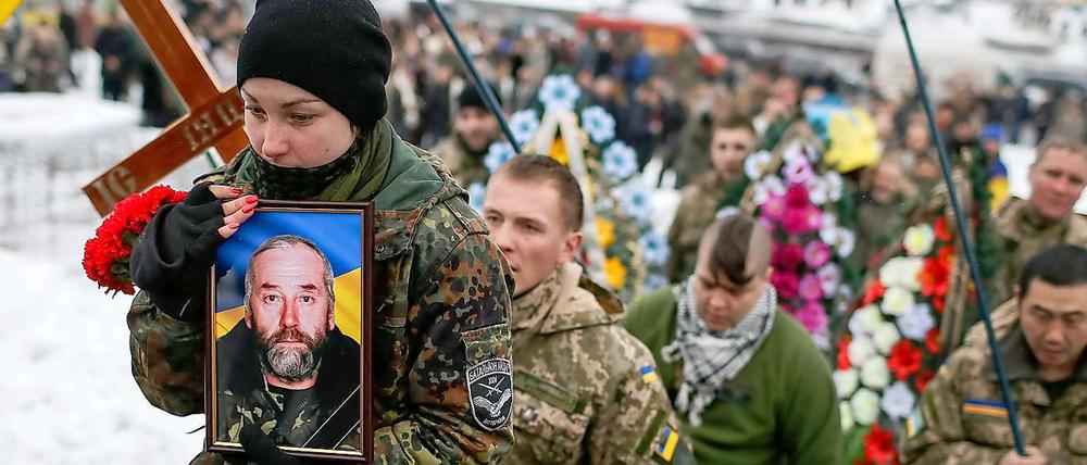 Die Tochter trägt bei der Beisetzungszeremonie in Kiew das Foto ihres Vaters Sergiy vom Bataillon "Aydar", der bei Kämpfen in der Ostukraine ums Leben gekommen war. 