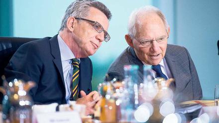 Kritiker unter sich. Innenminister Thomas de Maizière (l.) und Finanzminister Wolfgang Schäuble beraten sich vor einer Sitzung des Bundeskabinetts.