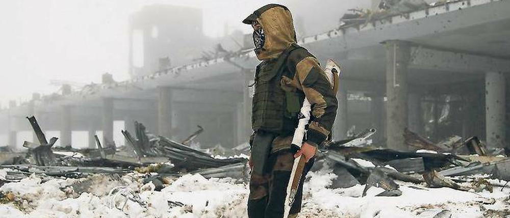 Ein Kämpfer in der selbst erklärten „Volksrepublik Donezk“ vor dem durch den Krieg weitgehend zerstörten Flughafen der Stadt. 