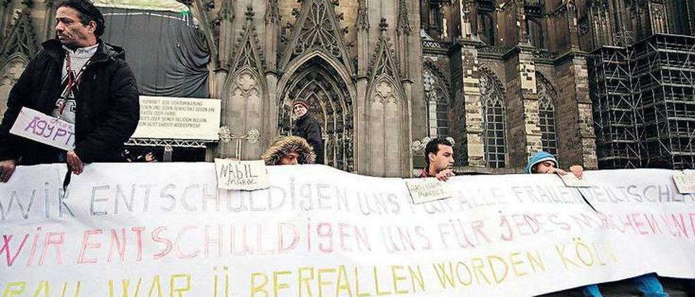 Flüchtlinge am Kölner Dom entschuldigen sich für die Übergriffe auf Frauen in der Silvesternacht durch andere Migranten aus dem Maghreb. 