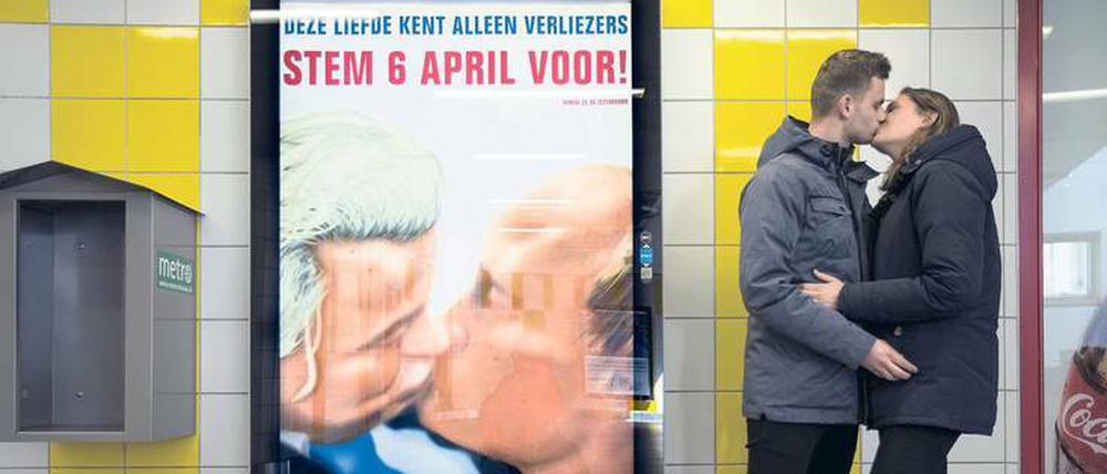 Nachmacher: Ein Pärchen küsst sich in Amsterdam neben einem Plakat, das Geert Wilders und Wladimir Putin bei einem Kuss zeigt. Diese Montage soll die Gegner eines EU-Ukraine-Assoziierungsabkommens in Putins Nähe rücken.