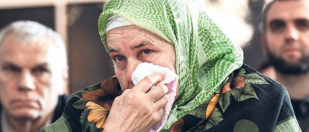 Tränen, die nicht versiegen. Eine Frau weint, während sie mit anderen Menschen eine TV-Liveübertragung aus dem Gerichtssaal des Den Haager Tribunals vom Prozess gegen Ratko Mladic verfolgt. 