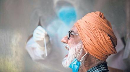 Ein Mann lässt sich in Delhi auf das Coronavirus testen.