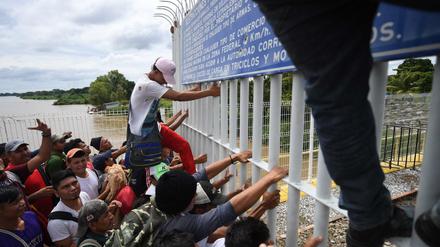 Migranten aus Honduras überwinden den Grenzzaun zwischen Guatemala und Mexiko.