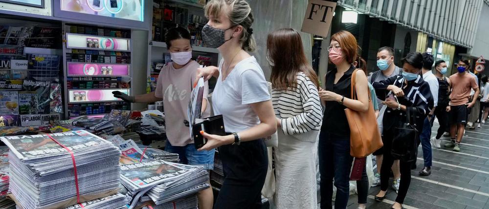 Hongkongs Einwohner:innen stehen Schlange, um das letzte Exemplar von "Apple Daily" zu kaufen.