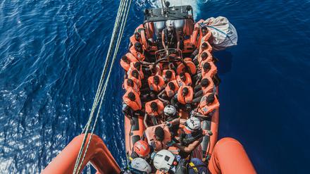Gerettete Migranten sitzen in einem Schlauchboot der Rettungsorganisation "Ocean Viking".