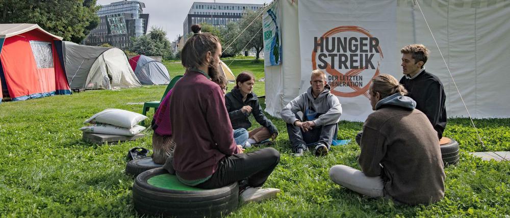 Umweltaktivisten sitzen vor einem Zelt in einem Camp in der Nähe des Reichstags. 