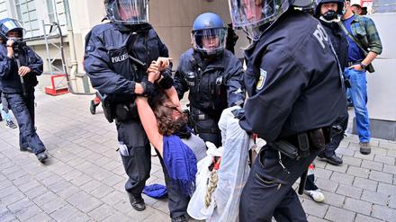 Eine Protestteilnehmerin wird während einer Demonstration gegen die Automesse IAA-Mobility von Polizisten weggetragen.