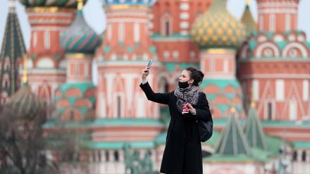 Eine junge Frau vor der Basilius-Kathedrale in Moskau. Russlands Hauptstadt ist schwer von der Corona-Pandemie betroffen.