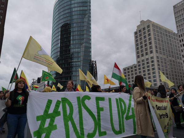 Mit den gelben Fahnen der multiethnischen SDF-Einheiten protestieren Kurden am Wochenende in Berlin.